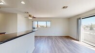 Located on Burbank Boulevard in the Van Nuys neighborhood of Los Angeles, this 2-bedroom, 2-bathroom unit is laid out on a single floor, offering a functional and comfortable living arrangement. The open living area is bright and airy, featuring light wood-style flooring, a ceiling fan with integrated lighting, and a wide window that frames neighborhood views and brings in generous natural light. A raised kitchen counter seamlessly divides the kitchen from the living space, maintaining an open feel while defining each area. The galley-style kitchen is well-equipped with warm wood cabinetry, dark countertops, stainless steel appliances including a gas range, dishwasher, refrigerator, and built-in microwave. The primary bedroom is a comfortable size, enhanced by large sliding glass doors that open onto a private balcony with open views of the surrounding neighborhood. The second bedroom features its own window with neighborhood views and a mirrored sliding closet. A hallway connects the bedrooms to the rest of the unit, with closet storage visible along the corridor. The bathrooms feature wood-toned vanities with dark countertops. Light wood-style flooring runs consistently throughout, tying the space together with a clean, cohesive aesthetic.