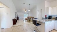 Located in Pinellas Park, Florida, this single-story, 2-bedroom, 2-bathroom home offers a well-designed open-concept layout that seamlessly connects the living room, dining area, and kitchen. The main living area features vaulted ceilings that amplify the sense of space, light-toned tile flooring, a ceiling fan, and a sliding glass door that fills the room with natural light and provides access to the outdoors. A media console with a built-in electric fireplace serves as a focal point in the living space.

The kitchen is outfitted with white cabinetry, granite countertops, black appliances, and a breakfast bar with bar seating — ideal for casual dining. A pantry provides additional storage. The primary bedroom features warm hardwood flooring, a ceiling fan, a walk-in closet, and a private en-suite bathroom with a glass-enclosed shower and dark slate-style tile flooring. The second bedroom, also with hardwood flooring, offers flexible use as a home office or guest room. The second bathroom features a soaking tub surrounded by elegant marble-style tile. Additional conveniences include a dedicated laundry area, three closets, and a hallway connecting the bedrooms and bathrooms.