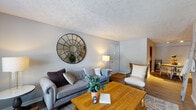 Located at 606 Mallard Creek Road in Louisville, Kentucky, this single-floor residence offers a thoughtfully designed layout with distinct living spaces that balance comfort and functionality. The living room serves as the heart of the home, featuring warm hardwood-style flooring, a textured ceiling, and neutral gray walls that create a calm, welcoming atmosphere. A large window allows natural light to fill the space, complemented by a decorative round mirror that adds visual depth. The room comfortably accommodates a full seating arrangement, making it well-suited for both relaxing and entertaining.

The kitchen is equipped with rich wood cabinetry, granite-style countertops, and stainless steel appliances, including a range and over-the-range microwave. The layout maximizes storage and counter space efficiently. Adjacent to the kitchen, the dedicated dining area features track lighting overhead and hardwood-style flooring, providing an inviting setting for meals.

The bedroom offers plush carpeting, a ceiling fan, and sliding doors that allow natural light to filter in. The bathroom includes warm wood vanity cabinetry, light countertops, a large mirror, and access to a walk-in closet and shower/tub combination, providing practical storage and comfort throughout.