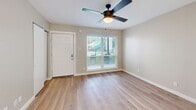 Located at 4425 Gilbert Ave in Dallas, Texas, this efficiently designed unit offers a practical and comfortable layout across a single floor. The living area is bright and inviting, featuring light-toned hardwood flooring that extends throughout the space, neutral beige walls, and a ceiling fan with an integrated light fixture that promotes airflow and comfort. A window fitted with horizontal blinds allows natural light to filter in while offering a view of the surrounding exterior, enhancing the open feel of the room.

The unit includes two bathrooms, each thoughtfully finished. One bathroom features a vanity with a white countertop, an undermount sink, gray shaker-style cabinetry with matte black hardware, and a dark wood-framed mirror illuminated by elegant globe sconce lighting. The second bathroom is fitted with a tub-shower combination clad in classic white subway tile, complete with chrome fixtures, providing a clean and timeless aesthetic.

The kitchen area, visible in the layout, includes stainless steel appliances, complementing the modern sensibility carried throughout the unit. The overall ambiance is clean, contemporary, and move-in ready, making this Dallas address a functional and stylish urban living option.