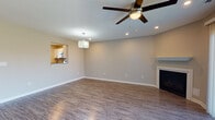 Located at 3894 N Chalet Cir in Beavercreek, Ohio, this two-story home offers a thoughtfully updated interior with a clean, modern aesthetic throughout. The main level centers around a spacious living area finished with durable wood-look flooring, recessed lighting, a ceiling fan, and a classic fireplace that serves as a focal point. Large sliding glass doors flood the room with natural light and provide views of the surrounding outdoor greenery. A pass-through window connects the living area to the kitchen, enhancing the open feel between spaces. The kitchen is well-appointed with white shaker-style cabinetry, granite countertops, and a full suite of stainless steel appliances including a refrigerator, dishwasher, range, and over-the-range microwave. A half bath on the main level features consistent granite finishes and gold-tone hardware. A staircase with white balusters leads to the upper level, where carpeted bedrooms offer a comfortable retreat. Each bedroom benefits from natural light through window treatments and is equipped with closet space, including one room featuring a walk-in closet with built-in shelving. An upper-level full bathroom includes a tub-shower combination and wood-look flooring, completing this well-appointed home.