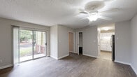 Located at 2310 W Cameo Ln in Knightdale, NC, this single-floor, one-bedroom, one-bathroom residence offers a thoughtfully designed layout with consistent wood-look flooring and neutral tones throughout. The living room is a bright, open space anchored by a ceiling fan and a sliding glass door that leads to a private patio, flooding the room with natural light and offering pleasant outdoor views of the surrounding greenery. A textured ceiling adds subtle architectural character throughout the home. The kitchen is efficiently designed with crisp white shaker-style cabinetry, granite-look countertops, a double-basin sink, and stainless steel appliances, including a refrigerator and dishwasher. A louvered bifold door provides a clean separation between the kitchen and the main living area. The spacious bedroom features a large window that brings in natural light, two dedicated closets — one of which is a walk-in — offering generous storage. The bathroom is clean and functional, appointed with a white vanity, solid countertop, and a well-lit mirror. With its move-in-ready finishes and practical floor plan, this residence delivers a comfortable and efficient living experience in Knightdale.