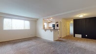 Located at 8001 York Rd in Towson, Maryland, this single-floor residence offers a practical and well-organized layout designed for comfortable everyday living. The expansive living area is finished with wall-to-wall carpeting and neutral-toned walls, creating a bright and welcoming atmosphere. A large window allows natural light to fill the space, enhancing its open feel. A half-wall pass-through connects the living area to the kitchen, which features white cabinetry, dark granite-style countertops, black appliances including a refrigerator, dishwasher, and built-in microwave, along with warm hardwood-style flooring. A window above the sink adds natural light to the kitchen workspace. Conveniently situated adjacent to the kitchen is an in-unit stacked washer and dryer. The bedroom is generously sized with plush carpeting and includes access to a walk-in closet, providing ample storage. The full bathroom is appointed with a white vanity, a tub/shower combination with a curved rod, hardwood-style flooring, and a small window for natural ventilation. A dedicated entryway with hardwood-style flooring and an electrical panel completes this thoughtfully laid-out single-level home.