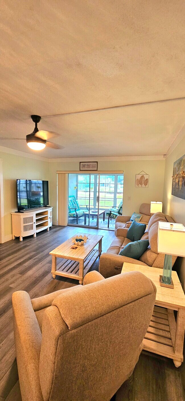 Sala de estar con puertas corredizas a planta baja y área verde. - 8740 Lueck Ln