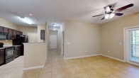This single-story home offers a thoughtfully designed layout across three bedrooms and two bathrooms, providing comfortable living with a range of practical features throughout. The interior is finished with neutral beige walls and light ceramic tile flooring in the main living areas, creating a bright and cohesive aesthetic.

The entry leads into an open-concept zone that connects the living room, dining room, and kitchen, enhanced by ceiling fans and pendant lighting. The galley-style kitchen is well-equipped with dark espresso cabinetry, granite-look countertops, black appliances including a refrigerator, range, microwave, and dishwasher, and a double sink — all complemented by a convenient pantry nearby.

The dining area features a pendant light fixture and flows seamlessly into the living space, which opens to a patio through elegant French doors, allowing natural light to pour in. The spacious primary bedroom includes plush carpeting and a ceiling fan, while the additional bedrooms offer similarly comfortable finishes. Both bathrooms are appointed with dark wood vanities and granite-style countertops, matching the kitchen's design language.

A dedicated laundry room houses a full-size washer and dryer with built-in shelving above. Eight closets throughout the home provide abundant storage. The overall ambiance is clean, neutral, and move-in ready.
