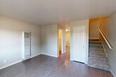 Located at 522 W K St in Benicia, CA, this two-story, 3-bedroom, 2-bathroom home is efficiently laid out across two floors of comparable size. The main floor features durable hardwood-style flooring throughout the living room, kitchen, and dining area. The combined kitchen and dining space is equipped with white cabinetry, ample counter space, a stainless steel sink, and a stainless steel refrigerator, with a door leading directly to a private patio. The living room is bright and open, with a staircase connecting to the upper level. A wall-mounted heater and a convenient half-bath with a vanity and wood-style flooring are also found on the main floor. Upstairs, three carpeted bedrooms offer a comfortable retreat, each served by ceiling fans. The primary bedroom features a large window with tree-lined views and ample natural light. The upstairs bathroom includes a full tub and shower combination with brushed nickel fixtures. A dedicated closet with double hanging rods provides practical storage. Hallways connect all upper-floor rooms efficiently, completing a functional and well-organized floor plan ideal for everyday living.