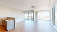 Located at 1 Race St in Philadelphia, PA, this three-bedroom, two-bathroom residence offers a thoughtfully designed single-floor layout with contemporary finishes throughout. Light hardwood flooring flows seamlessly across the entire unit, complementing the clean, neutral color palette.

The open-concept living room is a standout feature, wrapped in floor-to-ceiling glass windows on two sides that frame expansive views of the Philadelphia skyline, flooding the space with natural light. A ceiling-mounted HVAC unit adds a sleek, modern touch overhead.

The galley-style kitchen is well-appointed with stainless steel appliances—including a refrigerator, electric range, microwave, and dishwasher—paired with warm wood cabinetry, granite countertops, and a tile backsplash.

The primary bedroom features large windows with city views and ample closet space. The additional bedrooms are generously sized with hardwood floors and direct access to a shared bathroom. One bedroom includes dual closets, offering excellent storage. The bathrooms are finished with clean white tile, including a tub-shower combination with a glass enclosure.

A well-lit hallway with recessed lighting connects the private quarters to the living areas, completing a functional and modern urban residence.