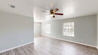 Located at 2400 Nordahl Dr in Augusta, Georgia, this single-story, 3-bedroom, 1-bathroom home offers a practical and comfortable layout. The open living area greets you with light gray walls, light-toned luxury vinyl plank flooring, multiple windows with blinds that invite ample natural light, and a ceiling fan with a built-in light fixture. A pendant light fixture marks the transition toward the kitchen area, adding a subtle design touch.

The galley-style kitchen is well-appointed with white cabinetry, granite-style countertops, a double stainless steel sink, a mosaic tile backsplash, and black appliances including an electric range with over-the-range microwave and refrigerator. The kitchen flows into a dedicated laundry area equipped with overhead wire shelving and hookups for a washer and dryer.

The spacious primary bedroom features plush carpeting, a ceiling fan, a generous closet, and a window with natural light. The two additional bedrooms are similarly finished with carpet, ceiling fans, and windows. One bedroom features vinyl plank flooring, offering versatility as a home office or flex space.

The full bathroom includes a tub/shower combo, a toilet, a vanity with storage, and wood-look vinyl flooring. A connecting hallway ties all rooms together in a cohesive, easy-to-navigate floor plan.