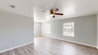 Located at 2400 Nordahl Dr in Augusta, Georgia, this single-story, 3-bedroom, 1-bathroom home offers a practical and comfortable layout. The open living area greets you with light gray walls, light-toned luxury vinyl plank flooring, multiple windows with blinds that invite ample natural light, and a ceiling fan with a built-in light fixture. A pendant light fixture marks the transition toward the kitchen area, adding a subtle design touch.

The galley-style kitchen is well-appointed with white cabinetry, granite-style countertops, a double stainless steel sink, a mosaic tile backsplash, and black appliances including an electric range with over-the-range microwave and refrigerator. The kitchen flows into a dedicated laundry area equipped with overhead wire shelving and hookups for a washer and dryer.

The spacious primary bedroom features plush carpeting, a ceiling fan, a generous closet, and a window with natural light. The two additional bedrooms are similarly finished with carpet, ceiling fans, and windows. One bedroom features vinyl plank flooring, offering versatility as a home office or flex space.

The full bathroom includes a tub/shower combo, a toilet, a vanity with storage, and wood-look vinyl flooring. A connecting hallway ties all rooms together in a cohesive, easy-to-navigate floor plan.