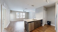 Located at 2470 Cheshire Bridge Rd NE in Atlanta, GA, this well-appointed one-bedroom, one-bathroom residence offers a thoughtfully designed layout across a single floor. The open-concept kitchen and living area serves as the heart of the home, where warm hardwood-style flooring flows throughout. The kitchen is equipped with stainless steel appliances — including a refrigerator, range, and microwave — complemented by sleek quartz countertops, a subway tile backsplash, two-tone cabinetry in dark wood and white, and a peninsula with an undermount sink that provides additional prep and seating space. Track and pendant lighting add a modern touch overhead. The living area is bright and airy, featuring multiple windows with natural light and a ceiling fan. The bedroom offers plush carpeting, its own ceiling fan, direct access to a private balcony through sliding glass doors, and convenient access to both a walk-in closet with wire shelving and the full bathroom. The bathroom features wood-grain cabinetry, quartz countertops, a tiled walk-in shower, and hardwood-style flooring. The dedicated walk-in closet provides ample storage with multi-level wire shelving. A private balcony extends the living space outdoors, completing this modern urban residence.