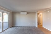 Located at 10210 N Foothill Blvd in Cupertino, CA, this well-appointed single-floor residence offers four bedrooms, two bathrooms, and a thoughtful layout designed for comfortable everyday living. The spacious combined kitchen and living room serves as the heart of the home, featuring plush carpeting, crown molding, a wall-mounted mini-split AC unit, and a classic fireplace. Sliding glass doors open directly onto a private balcony, filling the room with natural light and providing pleasant outdoor views of the surrounding foliage. The kitchen is efficiently designed with white shaker cabinetry, stainless steel appliances including a range, microwave, and refrigerator, dark countertops, and wood-look flooring. A separate dining room provides additional space for entertaining. The four bedrooms are carpeted and bathed in natural light from well-placed windows. Several bedrooms feature mirrored sliding closet doors, contributing to a bright and spacious feel. Each bedroom includes its own dedicated closet. The two bathrooms are clean and modern — one features a tub/shower combo with tile surround, a white vanity with dark countertop, and wood-look flooring, while the second offers a glass-enclosed shower. A dedicated laundry room and a connecting hallway complete this well-organized floor plan.