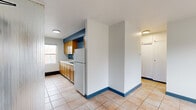 Located at 262 Birmingham St in Saint Paul, MN, this 2-bedroom, 1-bathroom residence offers a straightforward single-floor layout designed for efficient everyday living. Throughout the unit, light tan ceramic tile flooring and bold blue baseboards and accent walls create a consistent, recognizable design language.

The kitchen is well-appointed with warm honey-toned wood cabinetry lining the walls, a double stainless steel sink with a matte black faucet, white countertops, and a gas range. A window above the sink area brings in natural light and provides views of the surrounding neighborhood.

The living area features a large picture window that fills the space with natural light and offers an outdoor view of the tree-lined surroundings. The primary bedroom is a comfortable size, enhanced by a ceiling fan with a light fixture, a built-in closet, and a window overlooking the neighboring streetscape. The second bedroom is similarly bright, also fitted with a ceiling fan and natural light from a window.

The bathroom includes a full soaking tub with a white tile surround, a wood-cabinet vanity with a matte black faucet, a mirrored medicine cabinet, and a window for natural ventilation. The space offers a practical, cohesive design suited for comfortable urban living.