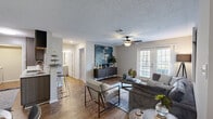 This thoughtfully designed 2-bedroom, 2-bathroom single-floor residence offers a comfortable and functional layout across a well-utilized footprint. The open-concept living and dining area serves as the heart of the home, featuring warm wood-look flooring, a ceiling fan, a textured ceiling, and a set of bright windows with access to the outdoors, allowing natural light to fill the space. The galley-style kitchen is efficiently arranged with dark wood cabinetry on both sides, quartz-style countertops, a white subway tile backsplash, stainless steel appliances including a refrigerator, microwave, and range, and a double-basin sink — providing ample workspace and storage. Both bedrooms are carpeted and include ceiling fans, offering a quiet and comfortable retreat. The spacious primary bedroom features generous closet access and room for full-sized furnishings. Each bathroom is finished with light cabinetry, quartz-style vanity countertops, large mirrors, and wood-look flooring, maintaining a clean and cohesive aesthetic. A dedicated laundry room houses a full-sized side-by-side washer and dryer set beneath overhead cabinetry, adding practical convenience. The overall design is consistent and modern, with neutral tones creating a welcoming ambiance throughout.