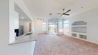 This contemporary apartment offers a well-designed living space of 970 square feet, comprising two bedrooms and two bathrooms. The open-concept layout seamlessly integrates the kitchen and living areas, promoting a spacious feel. The primary bedroom, measuring 180 square feet, provides ample space for relaxation.

The kitchen showcases modern amenities with sleek white cabinetry, stainless steel appliances, and granite countertops. A convenient breakfast bar enhances the functionality of the space. Throughout the apartment, large windows allow natural light to flood in, creating a bright and airy atmosphere.

Both bedrooms feature plush carpeting and are equipped with ceiling fans for comfort. The bathrooms are designed with practicality in mind, offering clean lines and modern fixtures. A unique built-in shelving unit in one of the rooms adds character and storage options.

The neutral color palette, predominantly white walls, and warm wood-tone flooring in common areas contribute to a fresh and inviting ambiance. This thoughtfully designed apartment combines style and functionality, perfect for modern living.