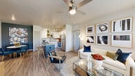Located at 8223–8227 N Union Blvd in Colorado Springs, CO, this thoughtfully designed 2-bedroom, 2-bathroom residence offers a comfortable and modern living experience across a single floor. The open-concept layout seamlessly connects the kitchen, dining, and living areas, creating a bright and airy communal space. The kitchen is outfitted with white shaker cabinetry, granite countertops, a subway tile backsplash, stainless steel appliances including a refrigerator, range, and microwave, and a center island with bar seating. The living room receives abundant natural light through large windows and features a ceiling fan overhead. A dedicated dining area is highlighted by a bold accent wall, adding a striking focal point to the space. Both bedrooms are carpeted and include ceiling fans, with the primary bedroom featuring a vaulted ceiling, a walk-in closet, and an en-suite bathroom with white cabinetry, granite countertops, and a soaking tub with tiled surround. The second bedroom also benefits from natural light and outdoor views. Wood-style plank flooring flows throughout the main living areas. A dedicated in-unit laundry room with side-by-side washer and dryer adds everyday convenience to this well-rounded residence.