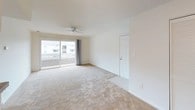 This single-floor, one-bedroom, one-bathroom unit offers a functional and comfortable layout designed to maximize everyday livability. The living area is bright and open, featuring neutral carpet flooring, a ceiling fan, and a sliding glass door that floods the space with natural light while providing outdoor access. A large closet with bi-fold doors offers generous storage directly off the living area.

The kitchen is laid out in a galley style, featuring warm wood cabinetry, dark granite-style countertops, and black appliances including a range, microwave, refrigerator, and dishwasher. Tile flooring, a stainless steel sink, and pendant lighting complete the space. A pass-through counter connects the kitchen to the living area, enhancing the sense of openness between the two spaces.

The bedroom is a comfortable, carpeted room with a ceiling fan and a window fitted with blinds that allow for natural light and privacy. The full bathroom features a tub-shower combination with white tile surround, a vanity with a white countertop, and a wall-mounted light fixture above the mirror, creating a clean and practical space.