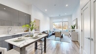 Located at 15 Washington Ave in Suffern, NY, this well-appointed 2-bedroom, 2-bathroom residence offers a thoughtfully designed single-floor layout with a clean, modern aesthetic. Light hardwood flooring flows throughout the open-concept living area, anchored by a spacious living room with large windows that invite abundant natural light and neighborhood views. Recessed lighting and crisp white walls contribute to an airy, contemporary atmosphere.

The kitchen is a standout feature, showcasing high-gloss gray cabinetry that extends to the ceiling, white quartz countertops, a subway tile backsplash, and a full suite of stainless steel appliances. A central island with seating provides a functional and stylish dining area that connects seamlessly to the living space.

The primary bedroom is generously proportioned, offering large windows with outdoor views, light hardwood floors, and a serene, neutral palette. The second bedroom mirrors this bright and comfortable character. Two full bathrooms serve the residence — one features a tub-shower combination with striking marble-style tile surround, while the second offers a clean, all-white finish with a vanity and tub-shower. Additional storage is provided by a dedicated closet. Overall, the space exudes a polished, move-in-ready quality with modern finishes at every turn.