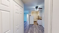 Located at 4323 N Division St in Davenport, Iowa, this two-bedroom, one-bathroom unit offers a practical and comfortable single-floor layout. Wood-look plank flooring runs consistently throughout, giving the space a cohesive and updated feel.

The living room is a bright, open area anchored by a large sliding glass door with vertical blinds, allowing generous natural light to fill the room. The galley-style kitchen features white cabinetry on both upper and lower levels, dark countertops with a built-in sink, and a full-size refrigerator. A ceiling fan with light fixture serves both the kitchen and adjacent areas, adding to the unit's functionality.

A central hallway connects the main living areas to the two bedrooms and the bathroom. The primary bedroom offers a bi-fold closet and ample floor space, while the second bedroom includes a window that brings in natural light. Both bedrooms feature neutral gray walls and textured ceilings.

The bathroom is equipped with a full tub and shower combination, featuring tiled surrounds and a built-in shower niche. Throughout the unit, consistent neutral tones and clean finishes create a simple, move-in-ready environment suited for comfortable everyday living.
