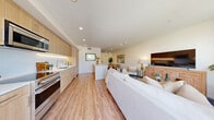 Located on West Sunset Boulevard in the heart of Los Angeles, this modern two-story home offers 3 bedrooms and 4 bathrooms across two thoughtfully designed floors. The main floor is anchored by an open-plan kitchen and living area, where light wood cabinetry with under-cabinet lighting, white quartz countertops, stainless steel appliances, and a breakfast bar peninsula create a sleek, functional hub. Wide-plank hardwood flooring flows seamlessly from the kitchen into the dining and living areas, which are filled with natural light from large windows. A convenient half-bath on the main floor adds practicality for guests. The upper floor houses the bedrooms, including a generously sized primary suite, along with additional well-appointed bathrooms featuring warm wood vanities, backlit mirrors, and clean stone tile flooring. A secondary living or flex space on the upper level opens to sweeping views of the Hollywood Hills and palm-lined skyline. Throughout the home, a consistent palette of warm neutrals, clean lines, and modern fixtures creates a bright, cohesive ambiance. The two-story layout, dual staircases, and efficient flow between spaces make this Sunset Boulevard residence a well-structured and stylish Los Angeles home.
