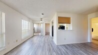 This single-floor, 3-bedroom, 2-bathroom home in Oklahoma City offers a practical and well-organized layout. The open living room features wood-style laminate flooring, a ceiling fan, a textured ceiling, and sliding glass doors that invite natural light and provide outdoor access. A pass-through window connects the living area to the galley-style kitchen, which is equipped with warm wood cabinetry, a double sink, a full suite of appliances including a refrigerator, range, and dishwasher, and a skylight that brightens the space. The kitchen also provides direct access to a dedicated pantry with built-in shelving. The primary bedroom is a comfortable size and features its own walk-in closet with shelving units and hanging rods for ample storage. The bathrooms include wood-toned vanities with countertop sinks and tub-shower combinations with white tile surrounds. Additional bedrooms are well-proportioned with access to closet space. A dedicated laundry room with shelving adds functional storage. Consistent laminate flooring runs throughout the home, creating a cohesive and easy-to-maintain aesthetic. The overall design is clean, neutral, and move-in ready.