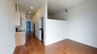 Located at 624 Yale Ave N, Unit 820 in Seattle, WA, this single-floor residence offers a clean, modern design with an open and functional layout. Warm hardwood-style flooring flows throughout the main living areas, complementing the crisp white walls and creating a bright, welcoming atmosphere.

The open-concept living area connects seamlessly to the kitchen, which is outfitted with light wood cabinetry, a stainless steel refrigerator, and a sink with contemporary fixtures — providing a practical and stylish space for everyday living and entertaining. Recessed lighting throughout ensures consistent, even illumination across the unit.

A central hallway connects the living and kitchen areas to additional rooms, with interior doors featuring classic paneled detailing with matte black hardware, offering a modern contrast against the neutral color palette. A mirrored element near the entry adds a functional design touch. The layout makes efficient use of space, with clearly defined zones that promote both comfort and ease of movement.

The unit's elevated position on the eighth floor places it within one of Seattle's most dynamic urban neighborhoods, South Lake Union, known for its proximity to major employers, restaurants, parks, and transit options. Overall, the unit presents a polished, move-in-ready interior with thoughtful design details throughout.