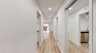Located at 450 E Wilbur Rd in Thousand Oaks, CA, this thoughtfully designed one-bedroom, one-bathroom residence offers a clean, modern aesthetic across a single floor. Light wood-tone flooring runs throughout, complemented by crisp white walls and recessed lighting that create a bright, welcoming atmosphere.

The open hallway connects all areas of the home seamlessly, leading to a well-appointed kitchen featuring white shaker cabinetry, dark quartz countertops, a classic subway tile backsplash, and stainless steel appliances. The living room is bathed in natural light courtesy of sliding glass doors that open directly onto a private balcony, offering pleasant outdoor views and a seamless indoor-outdoor connection.

The spacious primary bedroom provides a comfortable retreat with a mirrored sliding closet and neutral tones that enhance the sense of openness. The bathroom mirrors the home's refined design language, showcasing a white vanity with dark quartz countertops, gold-accented fixtures, and a clean, contemporary finish. Three closets throughout the unit offer generous storage. In-unit laundry adds everyday convenience, rounding out a well-planned residence designed for modern living in Southern California.