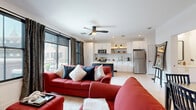 Located on Broadway in the heart of Saratoga Springs, NY, this well-appointed one-bedroom, two-bathroom residence offers a thoughtfully designed single-floor layout. Light hardwood flooring flows throughout, lending a clean and cohesive aesthetic to every room.

The open-concept kitchen and living area serves as the heart of the home. The kitchen is outfitted with white cabinetry accented by brushed gold hardware, a classic white subway tile backsplash, open wood shelving with warm lighting, stainless steel appliances, and a two-seat island — ideal for casual dining. The adjoining living area is bright and welcoming, featuring large black-framed windows and a glass sliding door that opens to a private balcony with city views. A fireplace and ceiling fan add comfort to the space.

The bedroom is a serene retreat with large windows dressed in dark curtains, light hardwood floors, and ample closet storage. Two bathrooms serve the residence: one features striking hexagonal charcoal floor tiles, a black-framed glass shower, and a white floating vanity with gold fixtures, while the second is clean and minimalist with light wood-tone flooring. A dedicated entrance completes this efficiently designed urban residence.