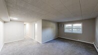 Located at 2616 Philadelphia Pike in Claymont, Delaware, this 2-bedroom, 1-bathroom unit offers a practical and well-organized single-floor layout. The kitchen stands out as a clear highlight, featuring two-tone cabinetry with white upper cabinets and gray lower cabinets, marble-look countertops, a mosaic tile backsplash, stainless steel refrigerator, and an electric range. A window brings in natural light, and an in-unit washer is conveniently integrated into the kitchen space. Light wood-look flooring completes the kitchen's modern aesthetic. The primary bedroom is generously proportioned, featuring a wide louvered bi-fold closet, a wall-mounted HVAC unit, a baseboard heater, and a window. The second bedroom offers comfortable space with a sliding door closet, baseboard heating, and a window for natural light. Both bedrooms feature neutral carpet and tile-panel ceilings. The bathroom includes a full tub and shower combination with white tile surround. A dedicated closet provides additional storage. The unit's neutral gray color palette and tile ceilings throughout create a cohesive and low-maintenance living environment.