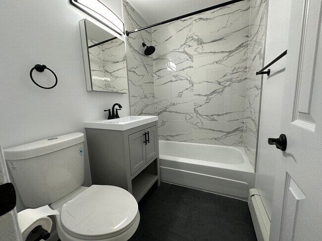 Baño con azulejos personalizados - Riverhill Apartments