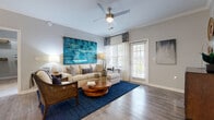 This single-story residence in Columbia, SC offers a comfortable and well-designed layout across two bedrooms and two bathrooms. The open living room serves as the heart of the home, featuring hardwood-style flooring, crown molding, a ceiling fan with light fixture, and generous natural light streaming through large windows with outdoor views. A sliding glass door provides direct exterior access, enhancing the bright and airy atmosphere.

The dining area adjoins the living space and is distinguished by a bold accent wall, chandelier lighting, and continued hardwood-style flooring, creating a defined yet cohesive gathering space. The kitchen is equipped with dark espresso cabinetry, granite-style countertops, black Whirlpool appliances, and durable wood-look flooring, offering both style and functionality.

The primary bedroom is a spacious retreat featuring plush carpeting, large windows with outdoor views, and a dedicated en-suite bathroom. The en-suite includes a dark-toned vanity with dual sinks, tile flooring, and well-lit mirrors. The second bedroom shares similar design elements. A dedicated laundry room houses a full-size Whirlpool washer and dryer. Two closets provide ample storage throughout the residence.