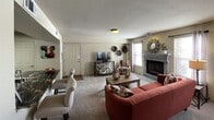 This single-floor residence offers a thoughtfully designed layout with a warm, cohesive aesthetic throughout. The living room serves as the heart of the space, centered around a wood-trimmed fireplace flanked by multiple windows that invite an abundance of natural light. A plush, carpet-covered floor anchors the seating area, which accommodates a sofa, accent chair, and a central coffee table. Decorative wall accents and a wall-mounted television add both character and functionality. An adjacent dining area transitions seamlessly into the living space, enhancing the open feel of the floor plan.

The kitchen is outfitted with dark espresso cabinetry, bold granite-style countertops, and stainless steel appliances including a range, microwave, and a full-size refrigerator. Tile flooring provides a durable and clean finish throughout the cooking area, and a breakfast bar offers additional counter space.

The bedroom is a restful retreat featuring a ceiling fan, ample closet access, and warm neutral tones accented with decorative wall art. The bathroom is finished with large-format floor tiles, a dark vanity topped with a striking stone countertop, a vessel sink, wall-mounted cabinetry, and a full tub-shower combination, completing this comfortable and functional residence.