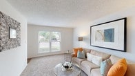 Located at 2144 Lakeshore Dr in Ridgeland, Mississippi, this single-floor residence offers a well-organized layout designed for comfortable everyday living. The living room serves as the heart of the home, featuring plush wall-to-wall carpeting, neutral walls, and a large window dressed with blinds that fills the space with natural light and offers views of the surrounding greenery outside.

Adjacent to the living area is a dedicated dining nook, illuminated by a pendant light fixture overhead, providing an intimate setting for meals and gatherings. The kitchen is thoughtfully designed with white cabinetry, granite-toned countertops, wood-look flooring, and a full suite of white appliances including a range, dishwasher, and refrigerator. A window above the sink allows for additional natural light.

The bedrooms are carpeted and comfortably sized, each featuring ceiling fans for year-round comfort. One bedroom includes sliding glass door access to an outdoor patio area, while another features bifold closet doors revealing generous storage space. Textured ceilings are present throughout the home, contributing to its classic residential character. A hallway connects the rooms with continuity, with wood-look flooring transitioning seamlessly between spaces. The overall ambiance is bright, clean, and inviting.