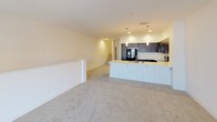 Located at 1257 Armorlite in San Marcos, this three-story residence offers a well-organized layout distributed across multiple levels, connected by carpeted staircases visible throughout the floor plan. The overall design is clean and contemporary, with crisp white walls, recessed lighting, and a neutral color palette that creates a bright, cohesive atmosphere throughout.

The kitchen is a standout feature, equipped with dark espresso-toned cabinetry, black appliances including a refrigerator, range, and over-the-range microwave, and light-colored countertops that provide strong visual contrast. Rich hardwood-style flooring grounds the kitchen area, while an adjacent peninsula with pendant lighting offers additional workspace and casual seating potential.

The living areas are finished with plush neutral carpet and transition smoothly between levels. One level features a spacious room with sliding glass doors opening to a balcony, allowing natural light and outdoor views to fill the interior. Carpeted hallways connect the upper-level rooms, one of which includes mirrored closet doors and access to additional storage.

The bathrooms are finished consistently with white tile surrounds, tub-shower combinations, hardwood-style flooring, and clean white fixtures, maintaining a uniform and functional aesthetic throughout the residence.