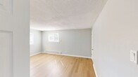 Located at 1127 Ward St in Chester, PA, this 2-bedroom, 1-bathroom unit offers a well-organized, single-floor layout finished with light hardwood-style flooring and soft gray walls throughout, creating a cohesive and refreshed aesthetic.

The spacious living room provides an open, airy feel with natural light and a textured ceiling, flowing easily into the rest of the unit via connecting hallways. The kitchen is well-appointed with white shaker-style cabinetry, marble-look countertops, a stainless steel sink, and a full suite of stainless steel GE appliances, including a range, over-the-range microwave, and refrigerator. A window allows natural light into the kitchen space.

Both bedrooms are comfortably sized with neutral gray walls, light flooring, and baseboard heating. The primary bedroom is notably roomy, offering a generous closet with double doors. The second bedroom also features a double-door closet and a window with outdoor views. The bathroom includes a clean, tiled tub and shower combination with a brushed nickel showerhead. Two hallways connect the rooms efficiently, contributing to a functional and practical floor plan throughout the unit.