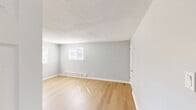 Located at 1127 Ward St in Chester, PA, this 2-bedroom, 1-bathroom unit offers a well-organized, single-floor layout finished with light hardwood-style flooring and soft gray walls throughout, creating a cohesive and refreshed aesthetic.

The spacious living room provides an open, airy feel with natural light and a textured ceiling, flowing easily into the rest of the unit via connecting hallways. The kitchen is well-appointed with white shaker-style cabinetry, marble-look countertops, a stainless steel sink, and a full suite of stainless steel GE appliances, including a range, over-the-range microwave, and refrigerator. A window allows natural light into the kitchen space.

Both bedrooms are comfortably sized with neutral gray walls, light flooring, and baseboard heating. The primary bedroom is notably roomy, offering a generous closet with double doors. The second bedroom also features a double-door closet and a window with outdoor views. The bathroom includes a clean, tiled tub and shower combination with a brushed nickel showerhead. Two hallways connect the rooms efficiently, contributing to a functional and practical floor plan throughout the unit.