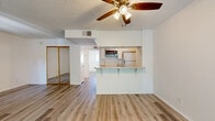Located on Vincennes Street in the Northridge neighborhood of Los Angeles, this single-floor, one-bedroom, two-bathroom home offers a well-organized and functional layout. Light wood-style flooring runs throughout the entire space, creating a cohesive and clean aesthetic.

The open-concept living area flows directly into the kitchen, which is designed in a galley style and features white cabinetry, granite-style countertops, a stainless steel double sink, a built-in dishwasher, a refrigerator, and an over-the-range microwave. A peninsula with an overhang serves as a breakfast bar, connecting the kitchen to the living area. A ceiling fan with integrated lighting anchors the living space above.

The bedroom offers a comfortable footprint, filled with natural light from a large window overlooking greenery. It includes a mirrored sliding-door closet, adding both storage and a sense of openness to the room.

The two bathrooms are finished in clean white tones with light wood flooring. One features a full tub and shower combination with sliding glass doors, a vanity with a granite-style countertop, and a window for natural light. The second bathroom provides a more compact layout with a toilet, vanity, and a small window.

The textured ceilings, bright white walls, and natural light throughout give the space a fresh, move-in-ready feel.
