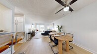 Located at 800 N Pennsylvania St in Denver's vibrant Capitol Hill neighborhood, this one-bedroom, one-bathroom residence offers a thoughtfully designed single-floor layout. The open living room is a standout feature, highlighted by large sliding glass doors that invite abundant natural light and provide views of the surrounding cityscape. The space accommodates a generous seating arrangement and flows seamlessly into a dedicated dining area, making it ideal for both relaxing and entertaining. Light-toned flooring and neutral walls create a bright, cohesive aesthetic throughout. The galley-style kitchen is efficiently laid out, featuring white subway tile backsplash, gray cabinetry with updated hardware, white countertops, and stainless steel appliances including a full-size refrigerator and range. Light wood-look flooring ties the kitchen together cleanly. The carpeted bedroom offers a comfortable retreat with a spacious closet, wall-mounted shelving, and a window that brings in natural light. A direct connection to the bathroom adds convenience. The bathroom is cleanly finished with light flooring and functional fixtures. Throughout the residence, textured ceilings and clean white walls contribute to a consistent, well-maintained interior. This residence presents a practical and modern urban living option in the heart of Denver.