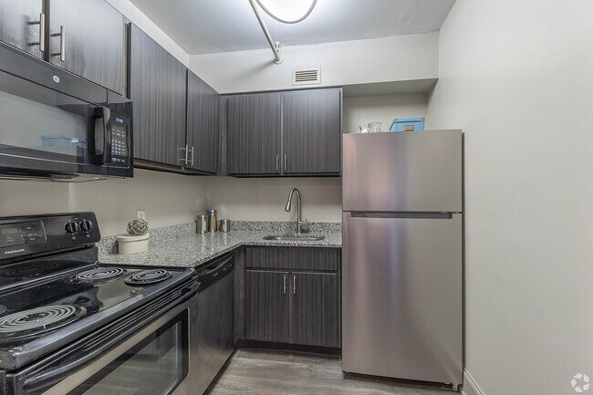 Cocina con encimeras de granito y electrodomésticos de acero inoxidable. - Vetra 500 Fifth