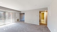 Located at 6301 N Front Street in Philadelphia, this single-floor 2-bedroom unit offers a practical and comfortable layout designed for everyday living. The generous living area is a standout feature, anchored by floor-to-ceiling sliding glass doors dressed with vertical blinds that invite abundant natural light and provide outdoor views. Neutral gray carpeting flows throughout the living space, complementing the light gray walls and clean white trim for a cohesive, understated aesthetic. A separate entry area with two white doors provides a defined threshold between the interior and exterior.

The kitchen is well-appointed with rich, dark espresso cabinetry, light-toned countertops, and stainless steel appliances including a gas range, built-in microwave, and dishwasher. Tile flooring grounds the space with a clean, durable finish.

Both bedrooms are carpeted and finished in soft neutral tones. One bedroom features a double-door closet, offering practical storage. The full bathroom includes tile flooring, a tub-shower combination with tiled surround, and a vanity with dark cabinetry, maintaining a consistent design language throughout the unit.