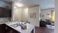 Located at 3853 Forest Park Ave in the vibrant 63108 neighborhood of St. Louis, Missouri, this single-floor residence offers a thoughtfully designed layout with modern finishes throughout. Rich hardwood-style flooring flows through the main living areas, creating a warm and cohesive aesthetic.

The open-concept kitchen is a standout feature, equipped with stainless steel appliances including a refrigerator, electric range, and microwave. Dark espresso cabinetry contrasts elegantly with granite-style countertops, and a peninsula with bar seating makes it an ideal space for casual dining and entertaining. Track lighting overhead provides ample illumination.

The kitchen opens seamlessly into the living area, which is bathed in natural light from multiple windows dressed with blinds and curtains. The space offers a comfortable, relaxed atmosphere well-suited for everyday living.

The bedroom features plush carpeting and a window that brings in additional natural light, contributing to a calm and restful environment. The bathroom is well-appointed with a full soaking tub and shower combination, hardwood-style flooring, and access to a walk-in closet, adding a practical touch to the private quarters.

Throughout the unit, neutral wall tones, clean lines, and modern fixtures create a cohesive and contemporary living environment.
