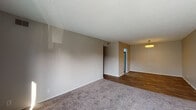 Located at 7131 Bronner Cir in Louisville, KY, this single-floor unit offers a practical and well-maintained layout with a series of clearly defined living spaces. The entry area transitions between wood-look plank flooring and plush carpeting, establishing a comfortable and cohesive aesthetic carried throughout the home.

The living area is generously proportioned, featuring neutral-toned walls, textured ceilings, and soft carpeting underfoot. A pendant light fixture illuminates the adjacent dining area, which connects directly to the updated kitchen. The kitchen is a standout feature, showcasing crisp white shaker-style cabinetry, light granite countertops, a stainless steel sink, and a suite of stainless steel appliances including a dishwasher and refrigerator, all set above wood-look flooring.

The bedrooms are carpeted and bathed in natural light through blinded windows, offering a calm and restful atmosphere with textured ceilings adding subtle dimension. The bathrooms feature wood-look flooring, neutral walls, and brushed nickel hardware accents. Louvered closet doors and practical storage solutions contribute to the unit's overall functionality throughout.