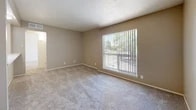 Located at 5327 Montgomery Blvd NE in Albuquerque, New Mexico, this one-bedroom, one-bathroom unit offers a well-organized, single-floor layout designed for comfortable everyday living. The open living area is finished with durable hardwood-style flooring near the entryway and plush carpet throughout, creating a warm and inviting atmosphere. A pass-through kitchen counter with overhead lighting connects the kitchen to the living space, where black appliances add a modern contrast to the bright, neutral-toned walls. The living area benefits from a large window dressed with vertical blinds, allowing natural light to fill the room while offering outdoor views. The carpeted bedroom is a comfortable retreat, featuring a ceiling fan with a light fixture, a built-in vanity with a mirror, a walk-in closet, and convenient access to the full bathroom. The bathroom is clean and functional, showcasing white tile surrounds, a soaking tub with an overhead shower, hardwood-style flooring, and classic chrome fixtures. Two closets provide ample storage throughout the unit. Neutral tones, textured ceilings, and consistent finishes lend the space a cohesive, move-in-ready character.