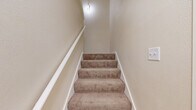 Located at 8183 N 107th St in Milwaukee, WI, this two-story, one-bedroom, one-bathroom unit offers a thoughtfully designed layout across its two levels. The main living floor hosts the majority of the space, including a galley-style kitchen outfitted with crisp white cabinetry, granite-look countertops, a stainless steel refrigerator, and light wood-look flooring that ties the space together with a clean, modern aesthetic. A dedicated laundry area includes an in-unit washer and water heater, adding everyday convenience. The spacious bedroom is carpeted for comfort and features a large double-door closet, offering generous storage. Neutral, warm-toned walls throughout create a bright and inviting atmosphere. The full bathroom is well-appointed with white cabinetry, a granite-style countertop with an undermount sink, a large vanity mirror, and a separate water closet with a tub-shower combination and wood-look tile flooring. Baseboard heating and ceiling ventilation ensure year-round comfort. The overall design emphasizes clean lines, neutral tones, and functional living, making this a practical and comfortable space in a residential Milwaukee neighborhood.
