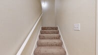 Located at 8183 N 107th St in Milwaukee, WI, this two-story, one-bedroom, one-bathroom unit offers a thoughtfully designed layout across its two levels. The main living floor hosts the majority of the space, including a galley-style kitchen outfitted with crisp white cabinetry, granite-look countertops, a stainless steel refrigerator, and light wood-look flooring that ties the space together with a clean, modern aesthetic. A dedicated laundry area includes an in-unit washer and water heater, adding everyday convenience. The spacious bedroom is carpeted for comfort and features a large double-door closet, offering generous storage. Neutral, warm-toned walls throughout create a bright and inviting atmosphere. The full bathroom is well-appointed with white cabinetry, a granite-style countertop with an undermount sink, a large vanity mirror, and a separate water closet with a tub-shower combination and wood-look tile flooring. Baseboard heating and ceiling ventilation ensure year-round comfort. The overall design emphasizes clean lines, neutral tones, and functional living, making this a practical and comfortable space in a residential Milwaukee neighborhood.