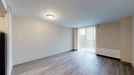 This well-maintained single-floor unit offers a thoughtfully laid-out living space with a clean, neutral aesthetic throughout. Light hardwood-style flooring flows consistently across the main living areas, bedrooms, and hallways, creating a cohesive and contemporary feel.

The spacious living room is a standout feature, bathed in natural light through a large sliding glass door fitted with vertical blinds, offering outdoor views and easy access to the exterior. The open, unobstructed layout provides ample room for furniture arrangement and everyday living.

The kitchen is equipped with warm-toned wood cabinetry, light stone-look countertops, a stainless steel sink, and a black Whirlpool gas range with overhead ventilation — a practical and functional setup for cooking and meal preparation.

The bedroom features a wide window with vertical blinds that invites natural light and garden views, along with a baseboard heater for year-round comfort. A generous built-in closet with bifold doors and a full-width shelf and hanging rod provides excellent storage.

The bathroom includes a full soaking tub and shower combination, a warm wood vanity with a white countertop and sink, a mirrored medicine cabinet, and bright overhead lighting. The overall ambiance of the unit is clean, bright, and move-in ready.