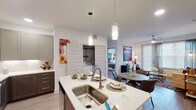 This single-story residence in Humble, Texas offers a thoughtfully designed open-concept floor plan across two bedrooms and two full bathrooms. The kitchen serves as a central hub of the living space, featuring stainless steel appliances, two-tone cabinetry with dark lower and light upper cabinets, crisp white quartz countertops, a subway tile backsplash, and a large island with a single-basin sink illuminated by pendant lighting. The kitchen flows seamlessly into the dining and living areas, where light wood-style flooring, a ceiling fan, and large sliding glass doors invite natural light throughout.

Both bedrooms are well-proportioned, each equipped with a ceiling fan, broad windows with blinds and sheer curtains, and light-toned flooring. The two full bathrooms feature soaking tubs with subway tile surrounds, clean white finishes, and light flooring for a bright, airy feel. An in-unit laundry closet adds everyday convenience. The layout also includes additional nook space suitable for a variety of uses. Throughout, the residence maintains a contemporary aesthetic with neutral walls, modern hardware, and consistent finishes that create a cohesive, polished ambiance.
