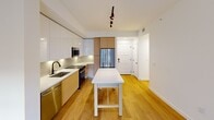 This contemporary 910 square foot apartment in North Miami offers a harmonious blend of style and functionality. The unit features three bedrooms, including a spacious 150 square foot primary bedroom, and two well-appointed bathrooms. The open-concept layout maximizes the living space, creating a seamless flow between rooms.

The kitchen is a standout feature, boasting sleek cabinetry in a striking two-tone design of white and mustard. High-end stainless steel appliances, ample counter space, and a central island make it ideal for both everyday meals and entertaining. The living area is bathed in natural light from large windows, offering picturesque views of the tropical courtyard below.

Hardwood floors run throughout the apartment, adding warmth and elegance to the space. The bathrooms are modern and luxurious, with marble-look tiles, backlit mirrors, and stylish fixtures. Bedrooms are generously sized, with large windows providing ample natural light and views of the lush surroundings.

The building itself is equally impressive, with a beautifully landscaped courtyard featuring a winding pool, palm trees, and various seating areas. This oasis-like setting provides residents with a tranquil retreat from the bustling city life. Located in North Miami, this apartment offers the perfect balance of urban convenience and tropical charm.