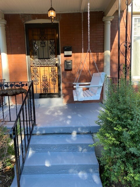 front door and relaxing polywood porch swing - 2918 N Gaylord St