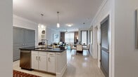 This well-appointed 2-bedroom, 3-bathroom residence in Allen, TX offers a thoughtfully designed single-floor layout that maximizes both comfort and functionality. The open-concept living area seamlessly connects the kitchen, dining, and living spaces, creating an inviting and airy atmosphere. Crown molding and light wood-style flooring flow throughout the main living areas, adding a polished, cohesive feel.

The kitchen is a standout feature, anchored by a large island with a dark granite countertop and bar seating for two. White cabinetry pairs elegantly with stainless steel appliances, including a refrigerator with ice maker, range, and over-range microwave. Pendant lighting above the island and track lighting above the cooking area ensure excellent illumination.

The primary bedroom is generously sized, featuring a ceiling fan, large windows with natural light, and direct access to a walk-in closet with built-in shelving. The en-suite primary bathroom impresses with dual granite-topped vanities, dark wood cabinetry, a soaking tub, and a separate glass-enclosed shower. The second bedroom is equally comfortable, with a ceiling fan and ample natural light. A second full bathroom features granite counters and a tub-shower combo. The spacious walk-in closet provides abundant storage with wire shelving throughout.
