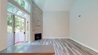 Located at 10125 Palms Blvd in the Palms neighborhood of Los Angeles, this single-level residence combines modern updates with architectural character. The living area immediately impresses with soaring vaulted ceilings that enhance the sense of openness, complemented by a dramatic floor-to-ceiling stacked stone fireplace serving as a striking focal point. Large windows and a glass-paned door invite abundant natural light and views of lush greenery, while light-toned hardwood-style flooring runs throughout the main living spaces.

The kitchen is thoughtfully appointed with white shaker cabinetry, grey countertops, a deep teal subway tile backsplash, and a full suite of stainless steel appliances including a gas range, refrigerator, dishwasher, and microwave. Plantation shutters on the kitchen window add a classic touch. A sputnik-style chandelier illuminates the dining area, adding a contemporary flair.

The hallway connects the main living areas to the private quarters, where bedrooms feature plush carpeting, crown molding, ceiling fans, and plantation-shuttered windows offering natural light and privacy. The bathroom showcases white cabinetry with grey countertops and clean, modern finishes. A walk-in closet provides generous storage. This well-maintained residence offers a cohesive blend of comfort and style in a prime Los Angeles location.